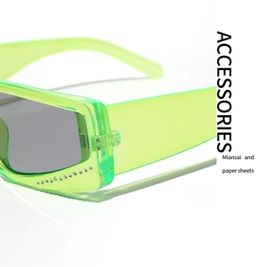 Close-up of neon green square sunglasses with studded rhinestones and grey lenses