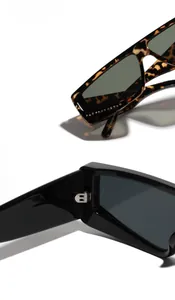 Detail view of square cat-eye sunglasses featuring metal hinges and printed frame specs