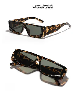 Detail view of tortoiseshell rectangle sunglasses featuring green lenses and rhinestone edges