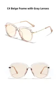 Détail des lunettes de soleil beige à monture large avec branches dorées et verres gris