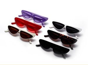 Flat lay of retro narrow cat-eye sunglasses in black, tortoiseshell, white, and red colors