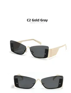 Close-up of rimless square sunglasses with gold metal temples and dark gray lenses