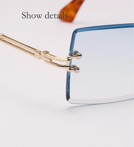 Detailed close-up of blue rimless sunglasses showing golden metal hinges and precise craft