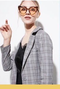 Detail of trendy heart-shaped sunglasses in leopard print styled with a gray blazer