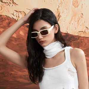 Chic cream white rectangle sunglasses with dark lenses on a model in desert setting