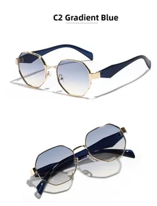 Détail de lunettes de soleil polygonales en métal doré avec verres dégradés bleu et jaune