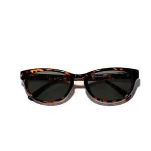 Lunettes de soleil œil de chat écaillé avec verres UV vert foncé sur fond blanc