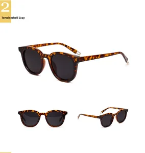 Détail de lunettes de soleil en écaille avec verres gris et charnières en métal