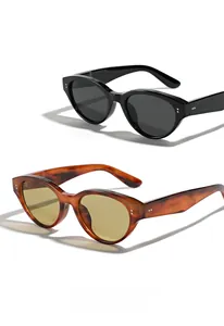 Close-up of cat-eye sunglasses with dual metal rivet accents in black and tortoise shell