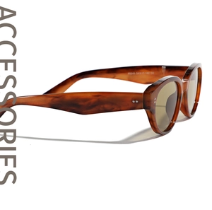 Detail of tortoise shell sunglasses showing frame texture and specifications on the temple