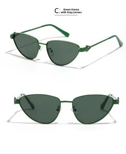 Détail de lunettes de soleil œil de chat avec monture en métal vert et verres gris