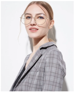 Detail of female model wearing round gold oversized metal frames with clear lenses
