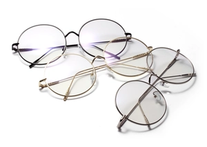 Detailed view of three metal round glasses frames in black, gold, and silver finishes