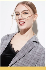 Close-up of stylish large round gold metal spectacles frame on female model face