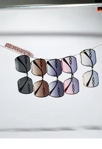 Dettaglio di 5 occhiali da sole quadrati stile punk chain appesi a supporti in corda