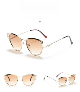 Détail des lunettes de soleil œil-de-chat en métal avec perles et verres marron dégradé