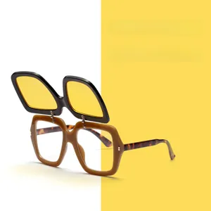 Detail of retro flip-up sunglasses featuring yellow lenses and tortoiseshell temples