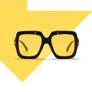 Close-up of vintage square oversized sunglasses with black frame and yellow tinted lenses