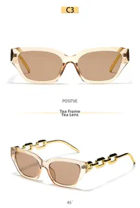 Detail of tea-colored cat eye sunglasses featuring decorative gold metal chain temples