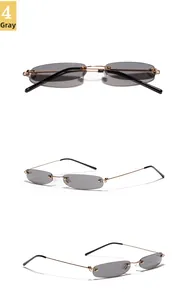 Detailansicht der goldfarbenen Metallbügel und grauen ovalen Gläser der randlosen Brille