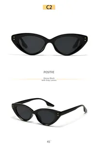 Detail view of black cat-eye sunglasses with golden rivets and dark lenses from two angles