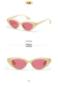 Detailed macro view of beige cat eye sunglasses with pink lenses and metal rivets