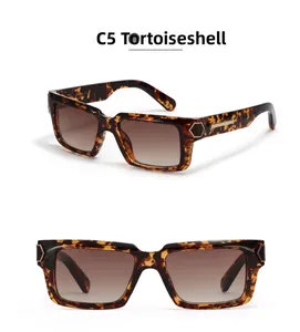 Detail of tortoiseshell Y2K square sunglasses with brown gradient lenses and gold metal rivets