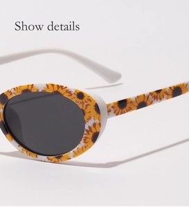 Gros plan sur la monture de lunettes de soleil blanche à motifs de tournesols et verres noirs