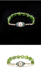 Detail of beaded evil eye bracelet with green crystals and gold plated accents