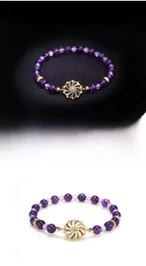 Macro shot of purple beaded bracelet with a colorful diamond spinning windmill charm