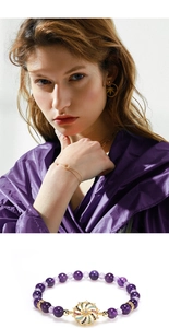 Detail of amethyst beaded bracelet with gold crystal flower charm on model wrist