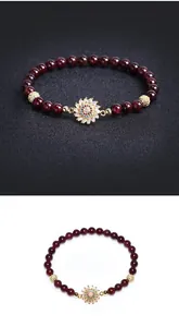 Détail du bracelet en perles de grenat avec pendentif tournesol en cristal sur fond noir