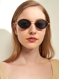 Detailansicht der Retro Oval Sonnenbrille mit goldfarbenem Metallrahmen und dunklen Gläsern