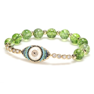 Fashion green beaded bracelet with sparkling crystal evil eye pendant on white background
