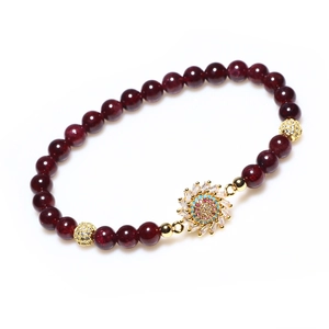Bracelet perlé en grenat avec pendentif tournesol en cristal doré sur fond blanc