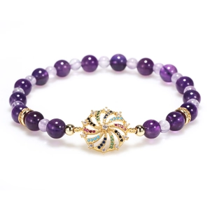 Colorful rhinestone amethyst bead bracelet with golden spiral pendant on white background