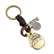 Close-up of vintage bronze keychain featuring a Totoro charm and engraved metal quote plaque