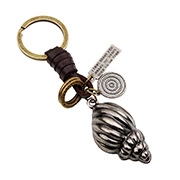 Macro shot of vintage alloy conch keychain with dark brown leather and bronze metal rings