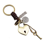 Close-up of a vintage-style brass heart padlock and key keychain with brown leather accents