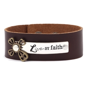 Détail du bracelet en cuir marron avec plaque Live BY Faith et accent de croix