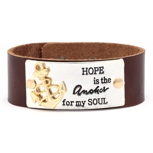 Détail d'un large bracelet en cuir marron avec plaque argentée et gravure ancre dorée