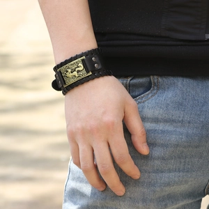 Wide black leather punk bracelet with antique bronze wolf head relief and woven edges