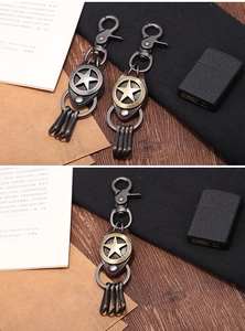 Gros plan d'un porte-clés punk pentacle vintage avec cuir et crochets sur table en bois