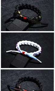 Macro detail of braided reflective shoelace bracelets with red heart buckle accents