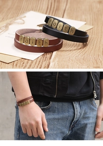 Détail d'un bracelet en cuir tressé avec perles en bronze épelant faith sur du bois