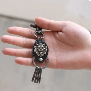 Handmade woven leather keychain featuring a vintage silver lion head and rotating lobster clasp