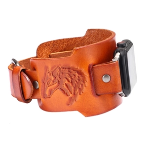 Detail view of brown cuff leather watch strap with embossed wolf head and silver studs
