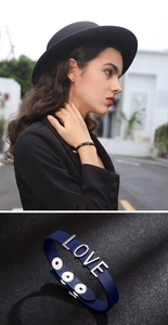 Detail of adjustable PU leather bracelet with metallic LOVE lettering and snap buttons
