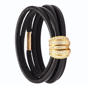 Detail of multi-layer black leather bracelet with crystal-studded gold magnetic clasp