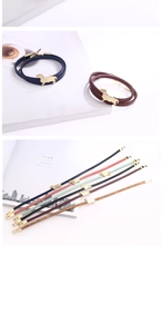 Detail of slim leather bracelets with golden dachshund charm and chic clasp closure